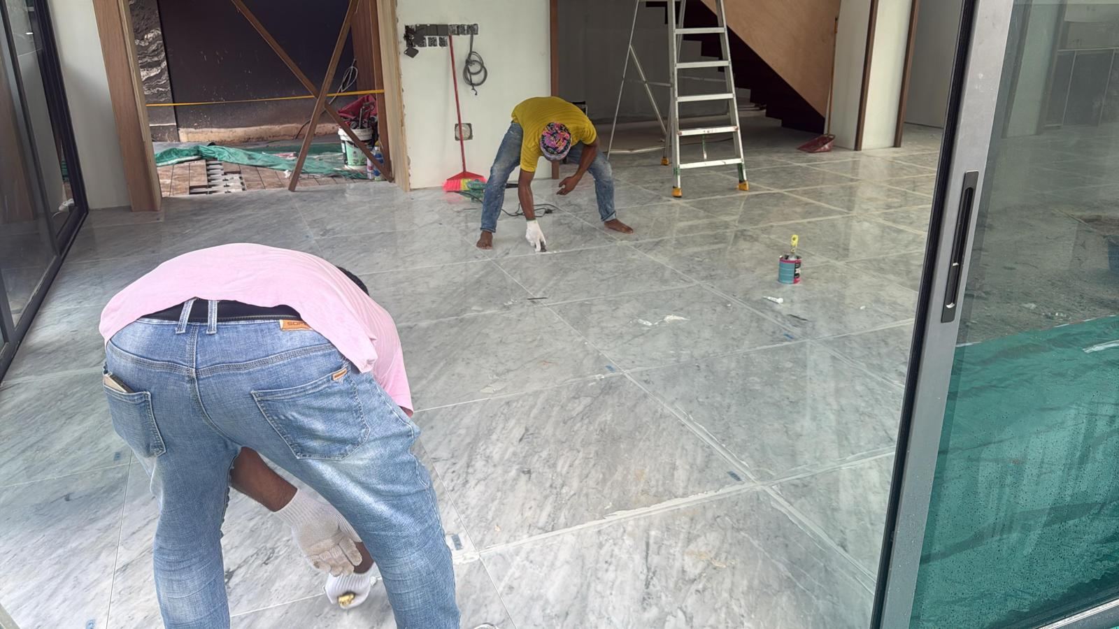 Real photo: our team working old grout out of a marble floor's joints by hand